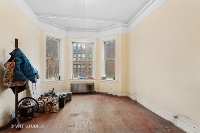 spare room featuring hardwood / wood-style floors and radiator