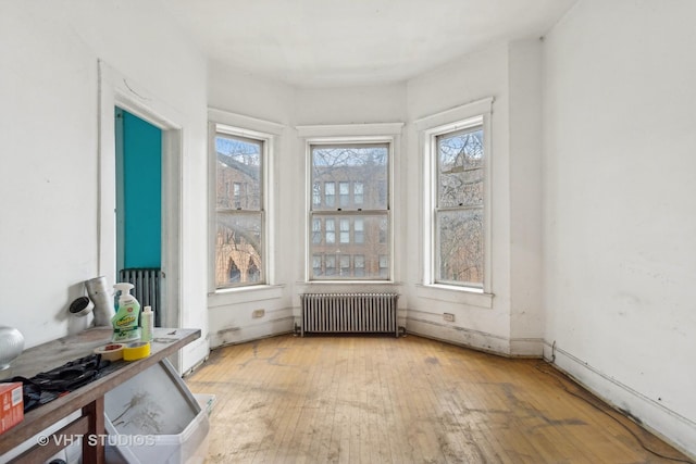 unfurnished sunroom featuring radiator heating unit