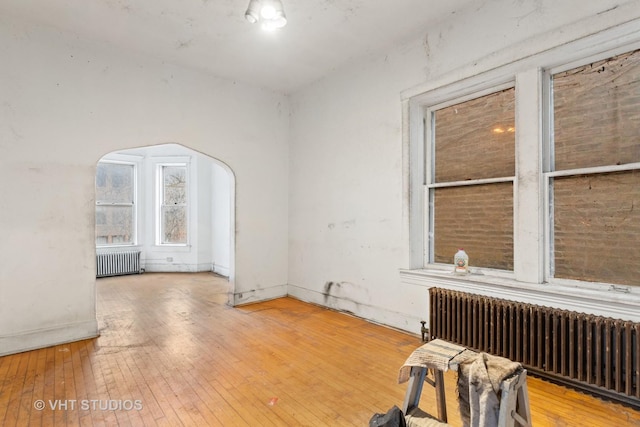 spare room with hardwood / wood-style floors and radiator