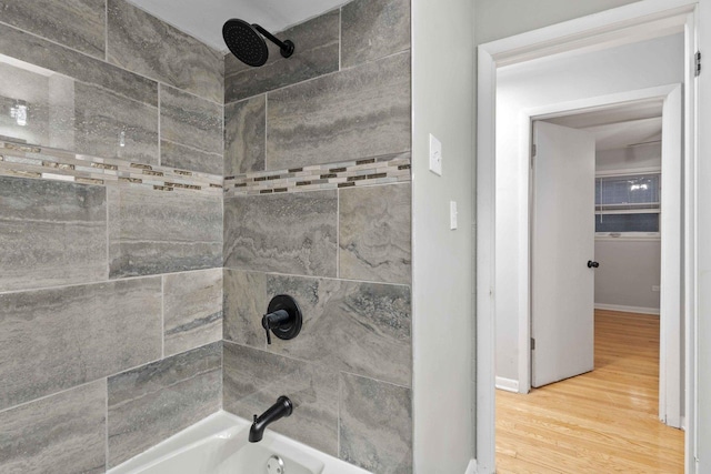 bathroom with wood-type flooring and tiled shower / bath combo