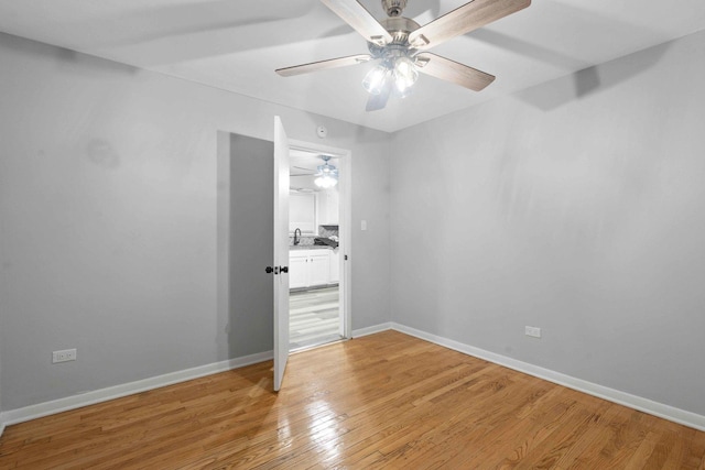 unfurnished room with sink and wood-type flooring