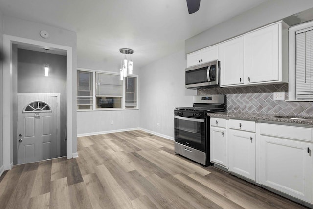 kitchen with tasteful backsplash, pendant lighting, white cabinets, and stainless steel appliances