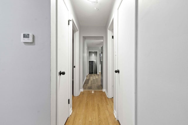 corridor with light hardwood / wood-style floors