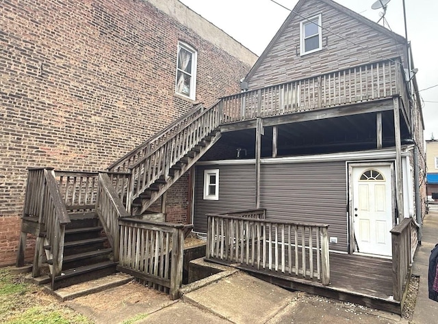 rear view of house featuring a wooden deck