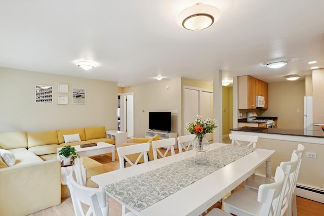 dining area featuring light wood-type flooring and a baseboard heating unit