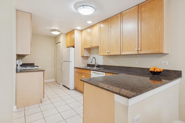 kitchen featuring light tile patterned floors, kitchen peninsula, light brown cabinets, white appliances, and sink