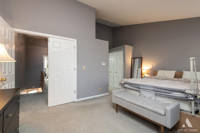 carpeted bedroom with a closet and a high ceiling