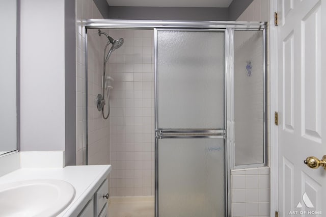 bathroom with a shower with door and vanity