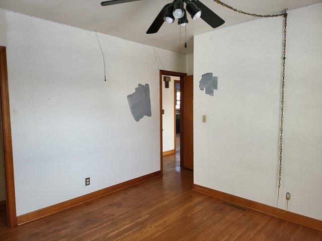 unfurnished room with ceiling fan and hardwood / wood-style flooring