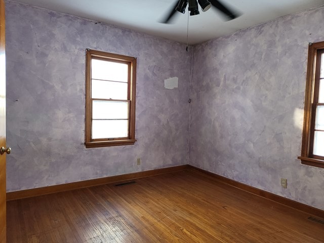 spare room with hardwood / wood-style flooring and ceiling fan