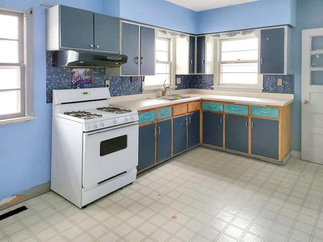 kitchen featuring sink, white range with gas stovetop, plenty of natural light, and blue cabinets