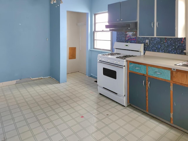 kitchen featuring decorative backsplash, blue cabinetry, white gas range, and sink