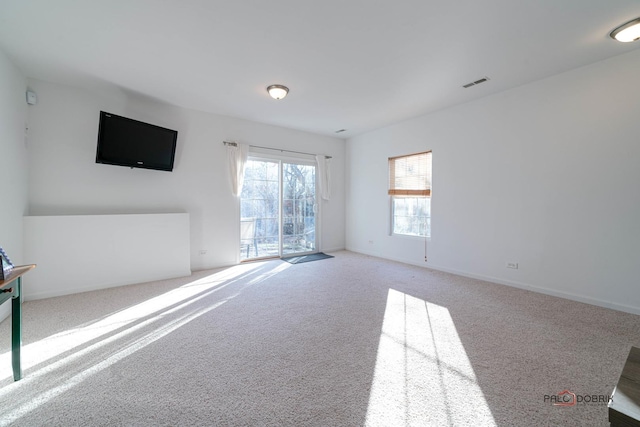 unfurnished living room featuring light carpet