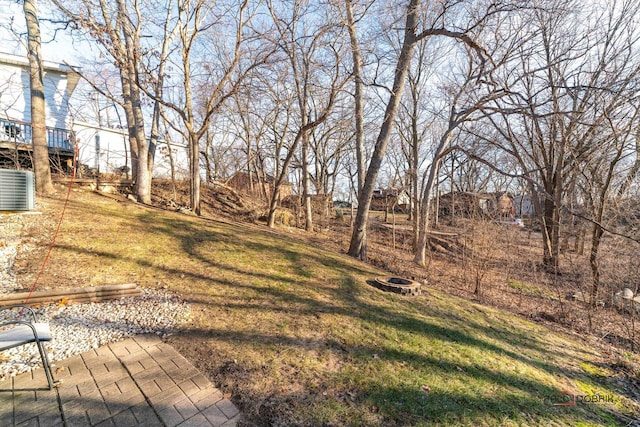 view of yard featuring central AC unit, a deck, and a fire pit