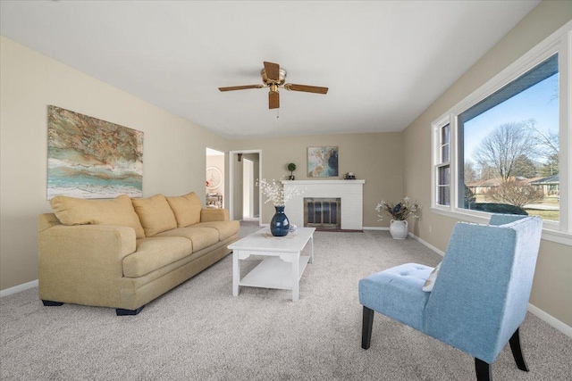 living room featuring light carpet, ceiling fan, and a fireplace