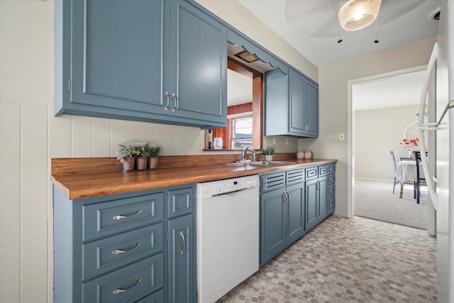 kitchen with sink, butcher block counters, blue cabinets, and white appliances