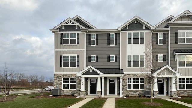 view of front of property with a front lawn and central AC unit