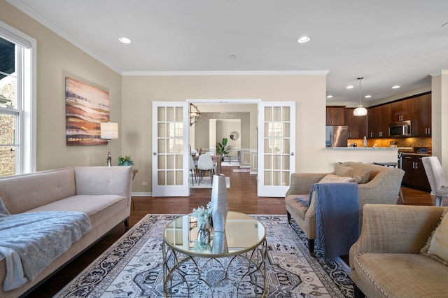 living room with dark wood-type flooring, ornamental molding, and french doors