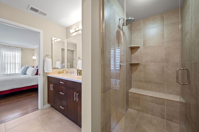 bathroom with an enclosed shower, vanity, and tile patterned floors