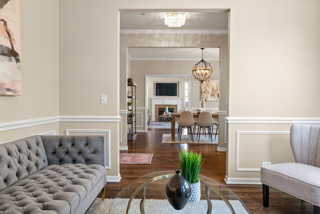 living room with ornamental molding, dark hardwood / wood-style flooring, and a notable chandelier