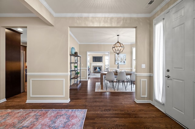 entrance foyer featuring ornamental molding, plenty of natural light, and dark hardwood / wood-style floors