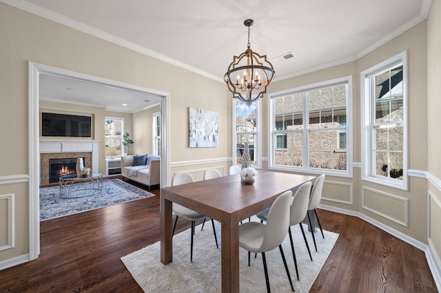 dining room featuring an inviting chandelier, ornamental molding, and dark hardwood / wood-style flooring