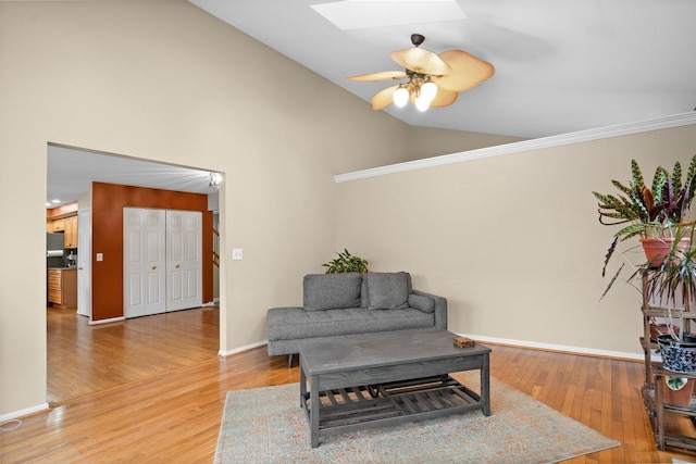 living area featuring a skylight, ceiling fan, high vaulted ceiling, and hardwood / wood-style flooring