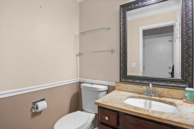 bathroom with crown molding, vanity, and toilet