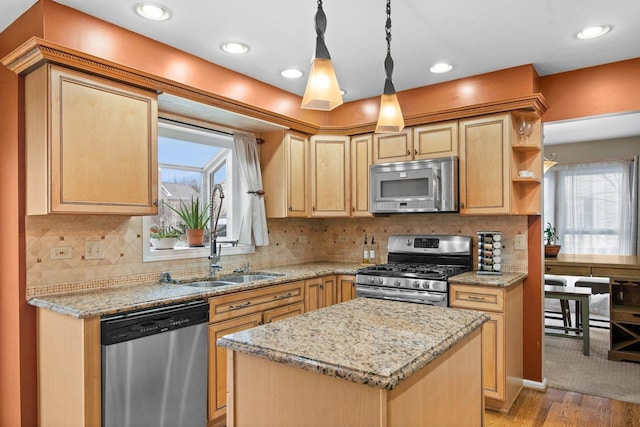 kitchen featuring a healthy amount of sunlight, a center island, stainless steel appliances, and light hardwood / wood-style floors