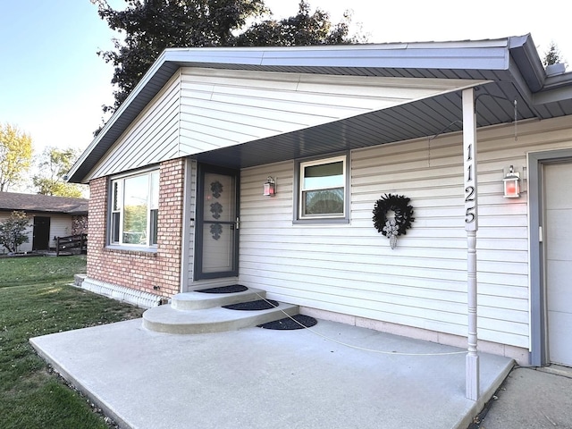 view of exterior entry with a yard