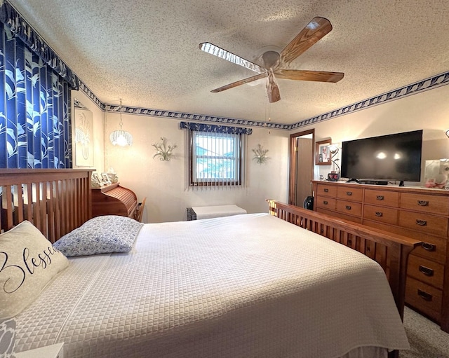 carpeted bedroom with ceiling fan and a textured ceiling