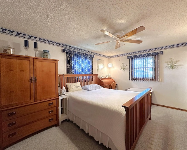 bedroom featuring ceiling fan, light carpet, and a textured ceiling