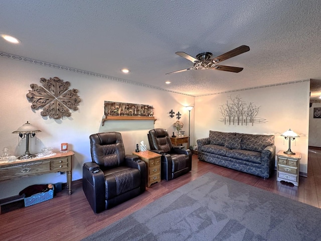 living room featuring dark hardwood / wood-style floors, ceiling fan, and a textured ceiling