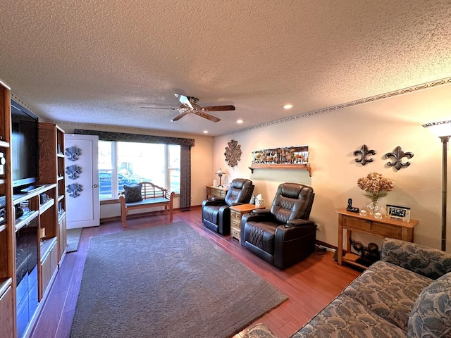 living room featuring hardwood / wood-style floors, ceiling fan, and a textured ceiling