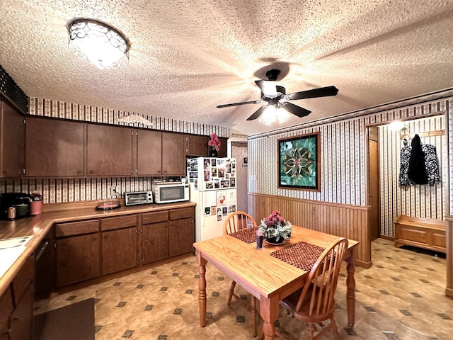 kitchen featuring ceiling fan, dark brown cabinetry, white appliances, and a textured ceiling