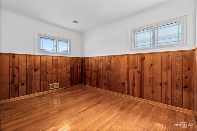 7825 N Oconto Ave, Niles, IL 60714 - unfurnished room featuring wainscoting, ornamental molding, wood finished floors, and wooden walls
