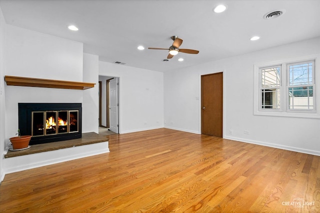 unfurnished living room featuring ceiling fan and light hardwood / wood-style flooring