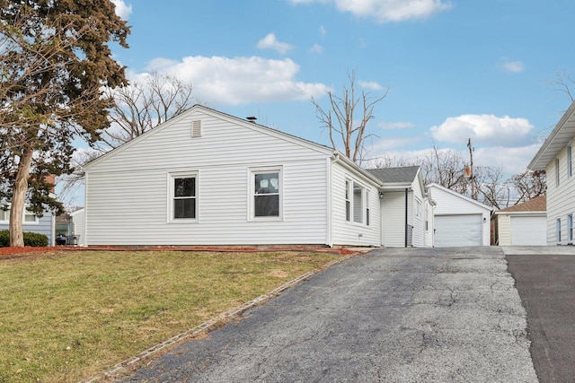 view of home's exterior with a yard, an outbuilding, and a garage