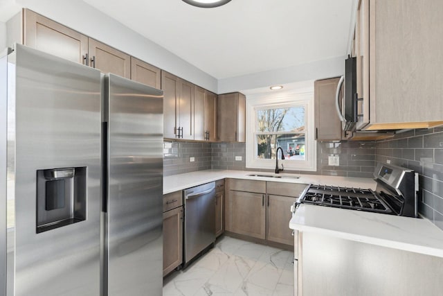 kitchen with decorative backsplash, sink, stainless steel appliances, and light stone counters