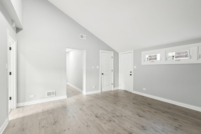 unfurnished room featuring light hardwood / wood-style floors and high vaulted ceiling