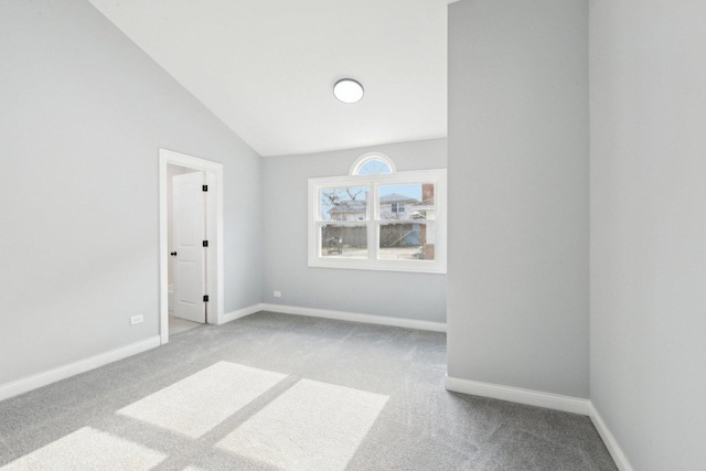 carpeted spare room with lofted ceiling