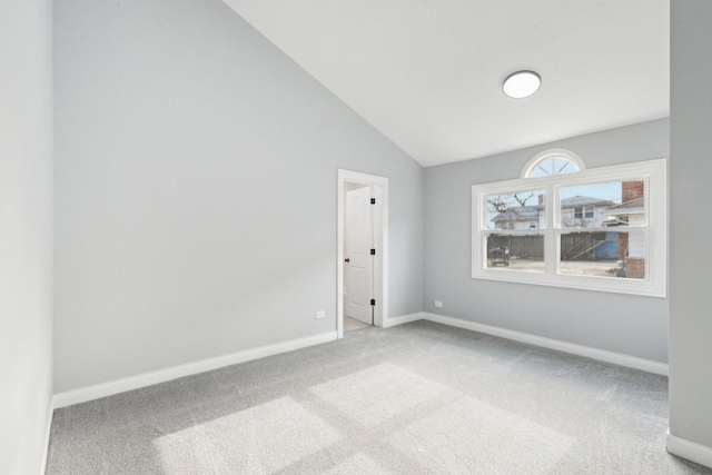 spare room featuring carpet and lofted ceiling