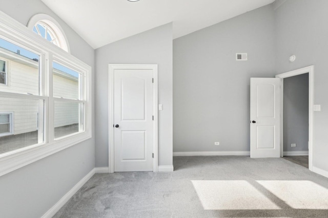 unfurnished bedroom with light carpet and vaulted ceiling