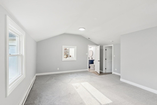 bonus room featuring a healthy amount of sunlight, light colored carpet, a baseboard radiator, and vaulted ceiling