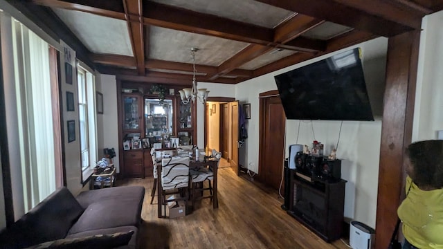 dining area with wood-type flooring, coffered ceiling, a notable chandelier, and beam ceiling