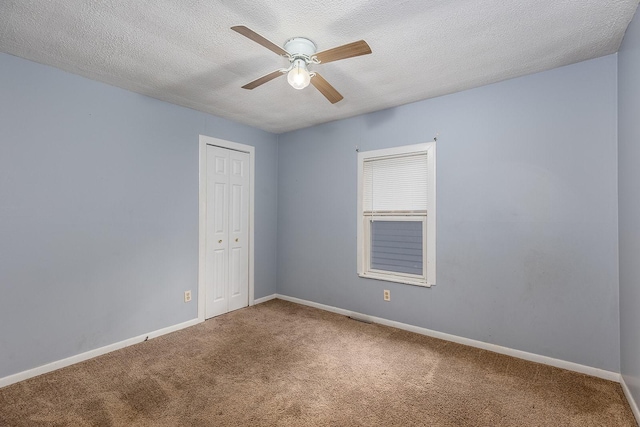 carpeted spare room with a textured ceiling and ceiling fan