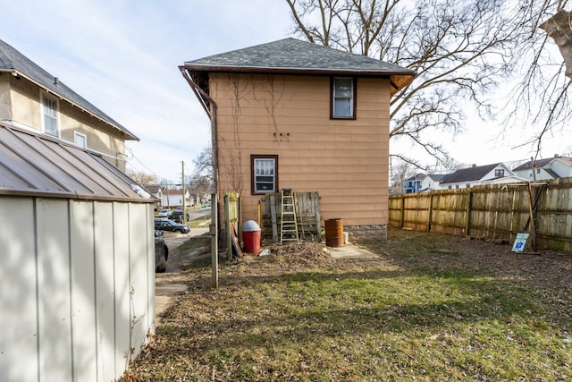 back of house with a yard and a storage shed