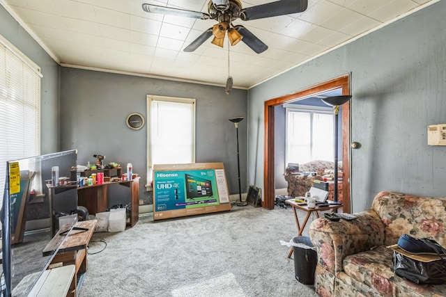 sitting room with carpet flooring, ceiling fan, and crown molding