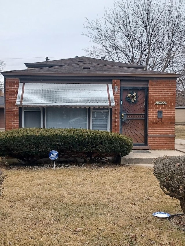 view of front of home with brick siding and a front yard