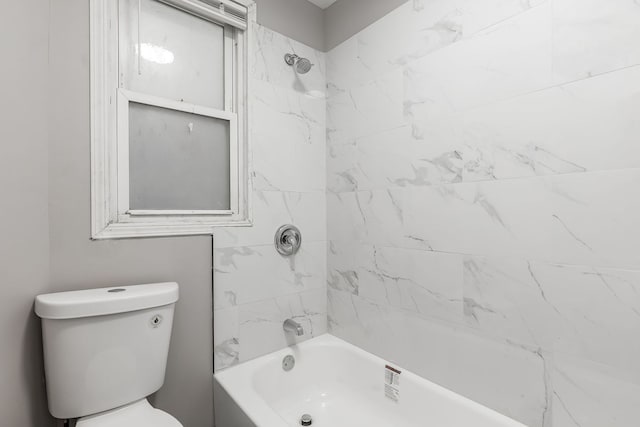 bathroom with toilet and tiled shower / bath